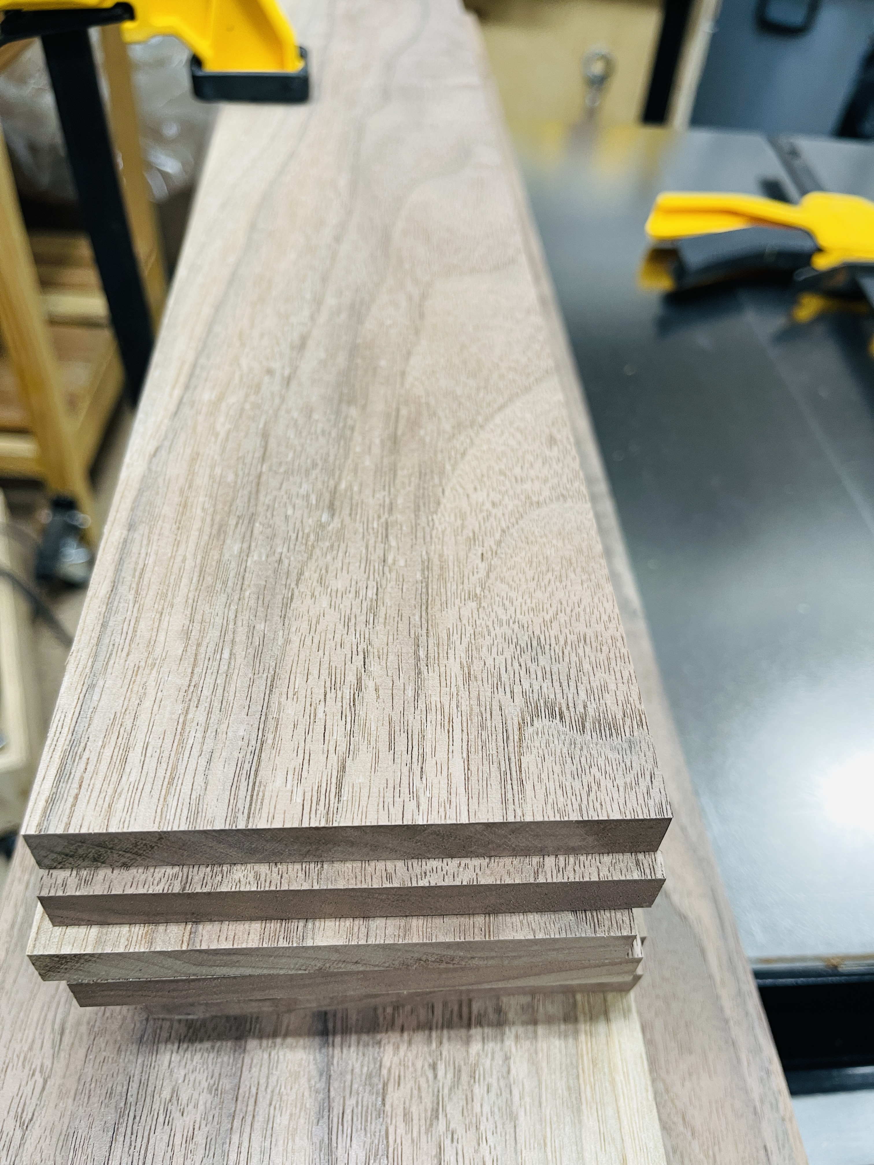 Stacked walnut boards showing rich grain detail