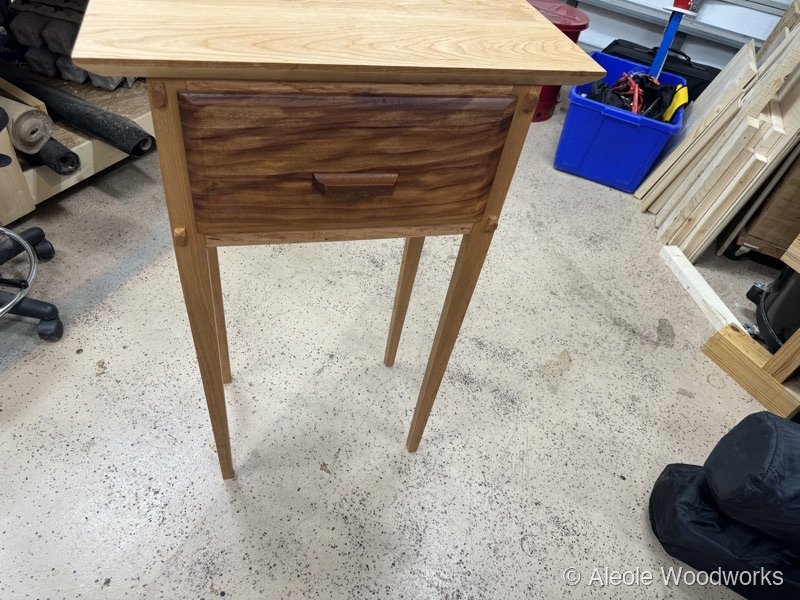 Side table detail showing walnut drawer front